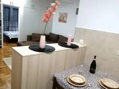 a living room with a table with a bottle of wine at MB apartman in Obrenovac