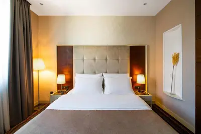 a bedroom with a large white bed with two lamps at CRYSTAL Hotel Belgrade in Belgrade