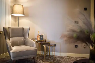 a room with a chair and a table with a lamp at CRYSTAL Hotel Belgrade in Belgrade