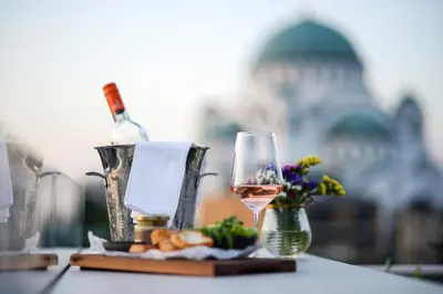 a bottle of wine and a plate of food and a glass at CRYSTAL Hotel Belgrade in Belgrade