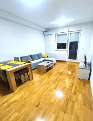 a living room with a couch and a table at Lux apartman Ub in Ub