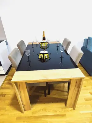 a dining room table with wine glasses and a black table at Lux apartman Ub in Ub
