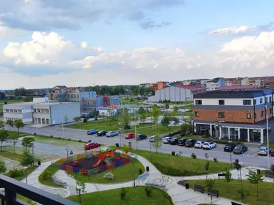a city with cars parked in a parking lot at Lux apartman Ub in Ub