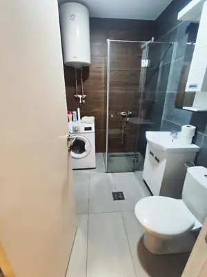 a bathroom with a toilet and a sink and a shower at Lux apartman Ub in Ub