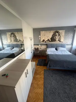 a bedroom with two beds and a dresser at LEO Central Apartment in Belgrade