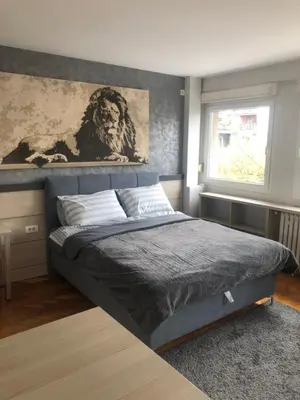 a bedroom with a bed with a painting on the wall at LEO Central Apartment in Belgrade