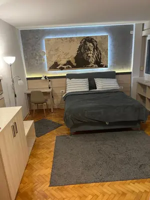 a bedroom with a bed with a painting on the wall at LEO Central Apartment in Belgrade