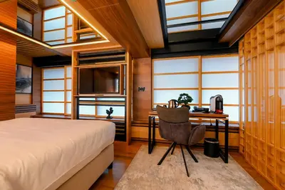 a bedroom with a bed and a desk and windows at Hanami Design Hotel in Belgrade