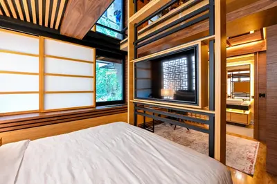 a bedroom with a bed and a tv and windows at Hanami Design Hotel in Belgrade