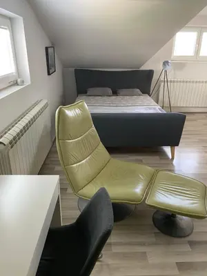 a bedroom with a bed and a yellow chair at Vila Sunset Jugovo in Udovice