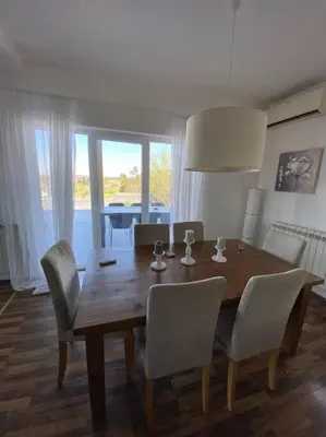 a dining room table with white chairs and a table and a table and chairsktop at Vila Sunset Jugovo in Udovice