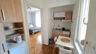 a small kitchen with a table and a small room at Apartment Nataly in Vračar (historical)
