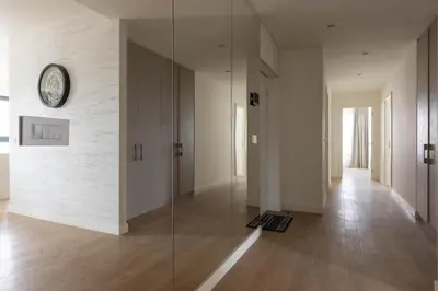 a glass hallway with a clock on the wall at Huge 3 Bedroom Apartment With River View in Belgrade