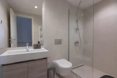 a bathroom with a toilet and a sink and a shower at Huge 3 Bedroom Apartment With River View in Belgrade