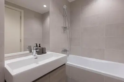 a white bathroom with a sink and a tub at Huge 3 Bedroom Apartment With River View in Belgrade