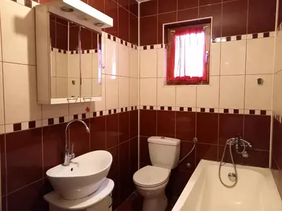 a bathroom with a toilet and a sink and a tub at Matisse Apartment Airport in Ledine