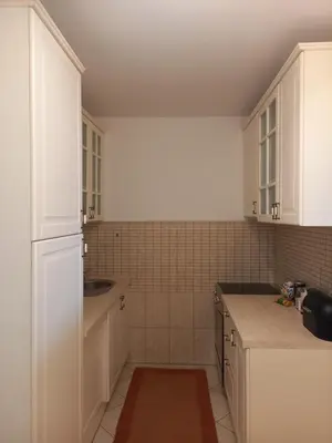 a kitchen with white cabinets and a sink at Matisse Apartment Airport in Ledine