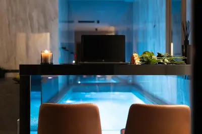 a desk with a laptop and a swimming pool at Marconio Luxury city center apartment with own spa zone in Belgrade