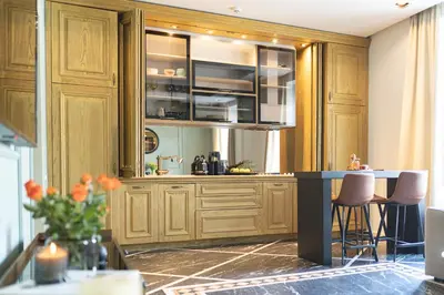 a kitchen with wooden cabinets and a counter with stools at Marconio Luxury city center apartment with own spa zone in Belgrade