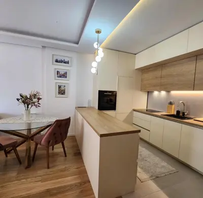 a kitchen with a table and a dining room at APARTMAN FLORENCE in Mirijevo