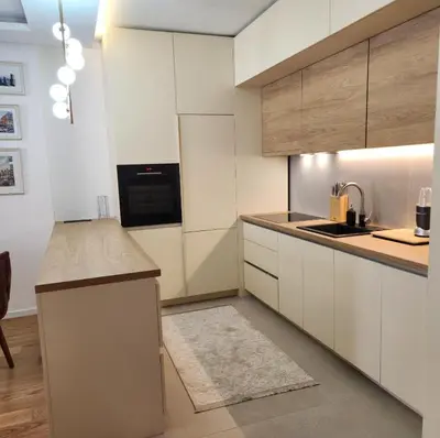a kitchen with white cabinets and a counter top at APARTMAN FLORENCE in Mirijevo