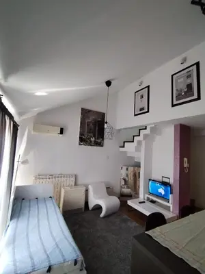 a bedroom with a bed and a living room with a staircase at MatIne Belgrade Zvezdara in Vračar (historical)