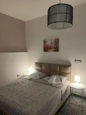 a bedroom with a bed and two tables with lamps at Sany Center Apartment in Belgrade