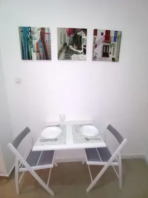 a table with two chairs and a white table with two pictures at Sany Center Apartment in Belgrade