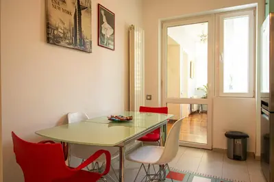 a dining room with a table and red chairs at City Center Apartment in Belgrade