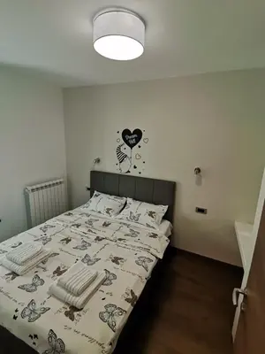a bedroom with a bed with a comforter on it at Hill Dreams Lux in Belgrade