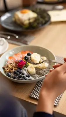 a plate of food with bananas and berries on a table at Hill Dreams Lux in Belgrade