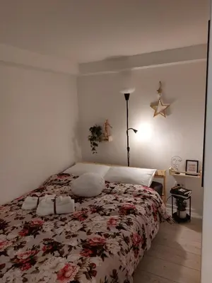 a bedroom with a bed with a floral bedspread at Bowler Hat Apartment Belgrade in Zvezdara