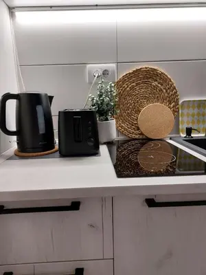 a kitchen counter with a coffee pot and a basket at Bowler Hat Apartment Belgrade in Zvezdara