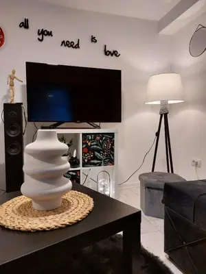 a living room with a flat screen tv on the wall at Bowler Hat Apartment Belgrade in Zvezdara