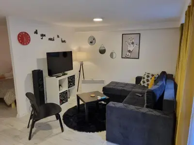 a living room with a couch and a tv at Bowler Hat Apartment Belgrade in Zvezdara