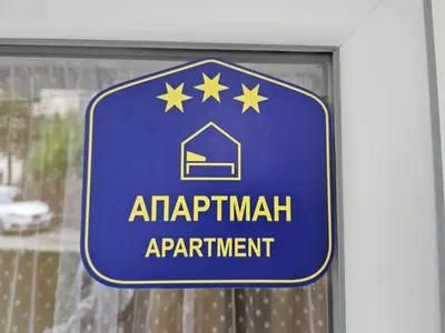 a blue sign for an apartment apartment on a window at Bowler Hat Apartment Belgrade in Zvezdara