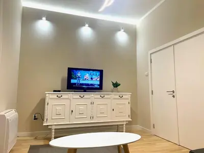 a living room with a tv on a white dresser at skadarlija bohemian in Belgrade