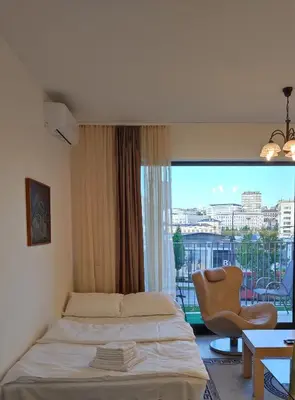 a bedroom with a bed and a chair and a window at Belgrade Waterfront Nabucco in Belgrade