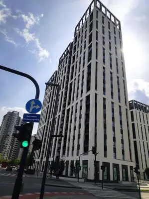 a large white building on a city street with a traffic light at Belgrade Waterfront Nabucco in Belgrade