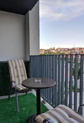 a patio with a table and chairs on a balcony at Belgrade Waterfront Nabucco in Belgrade