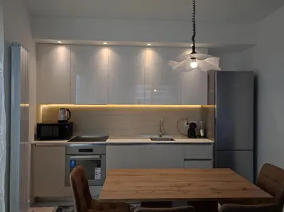 a kitchen with a table and a sink and a refrigerator at Belgrade Waterfront Carmen in Belgrade