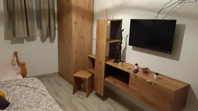 a bedroom with a television on a wall at Fruškogorski Đeram in Grgeteg