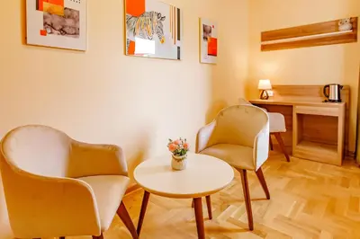 a room with two chairs and a table and a desk at Hotel AirStar in Surčin