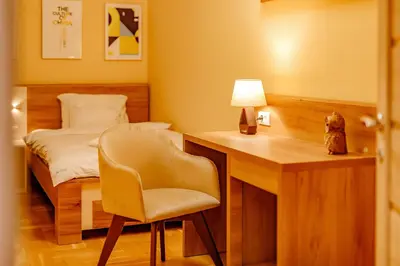 a bedroom with a desk and a bed and a chair at Hotel AirStar in Surčin