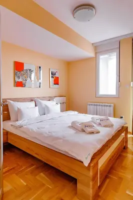 a bedroom with a large bed with white sheets at Hotel AirStar in Surčin