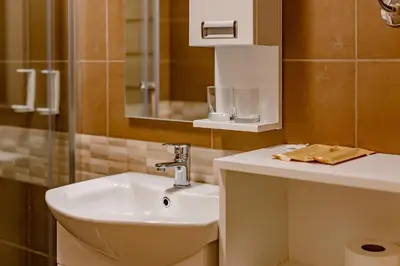 a bathroom with a sink and a toilet and a mirror at Hotel AirStar in Surčin