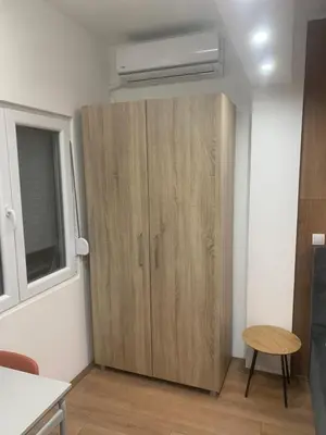 a large wooden cabinet in a room with a window at Nora in Bele Vode