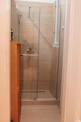 a shower with a glass door in a bathroom at Rustic Central Belgrade Stay in Belgrade