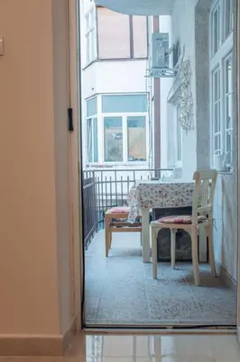 a room with a table and a bench on a balcony at Rustic Central Belgrade Stay in Belgrade