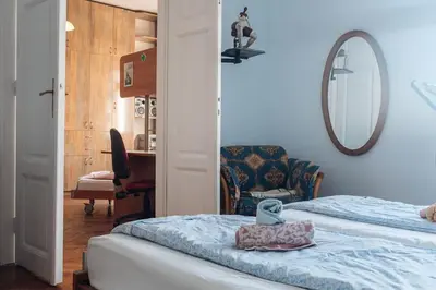 a bedroom with a bed and a mirror and a chair at Rustic Central Belgrade Stay in Belgrade